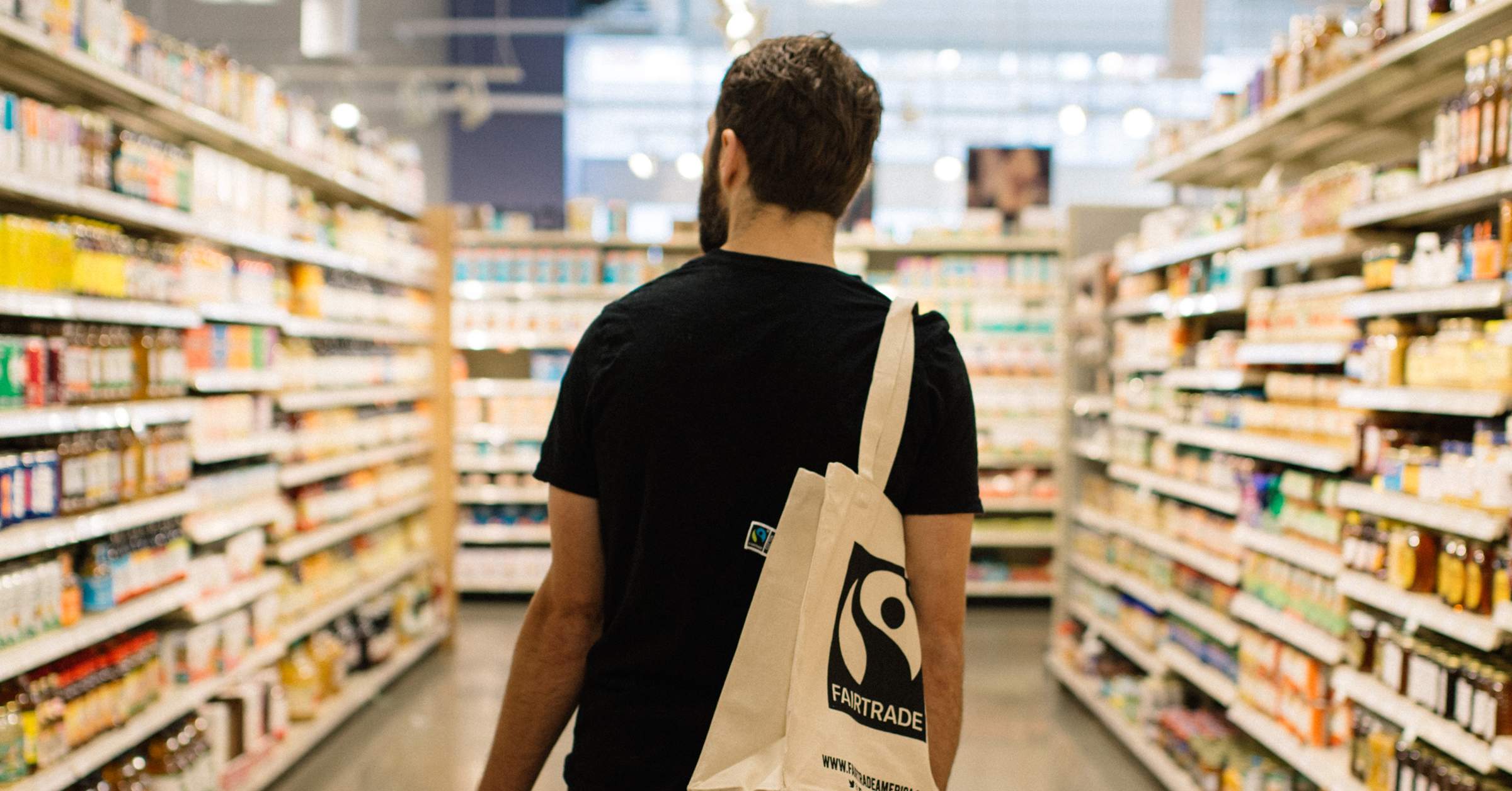 Person i butik med tygpåse med Fairtrade-logotyp